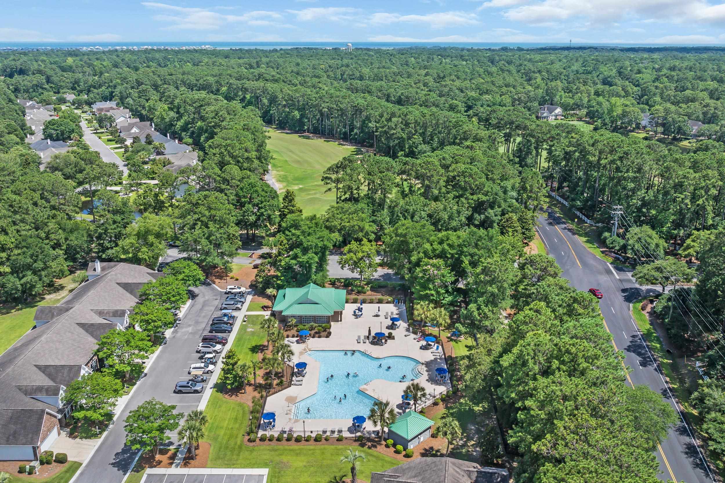 4436 Lady Banks Lane, Unit B2 Murrells Inlet, SC 29576 - Photo 29 of 36 Aerial view of property's location featuring a pool and a heavily wooded area