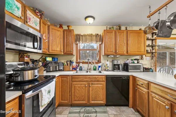 a kitchen with stainless steel appliances granite countertop a stove a sink dishwasher and cabinets with wooden floor