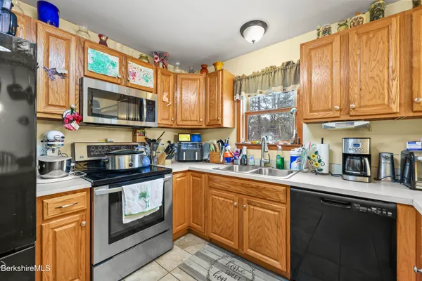 a kitchen with stainless steel appliances granite countertop a sink a stove and cabinets