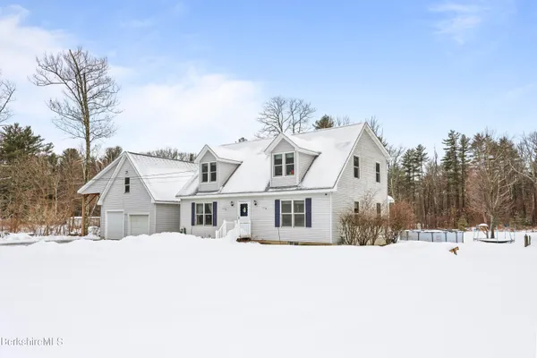a view of a white house with a snow on the road