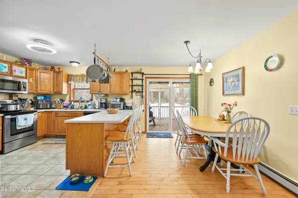 a dining room with stainless steel appliances a dining table and chairs