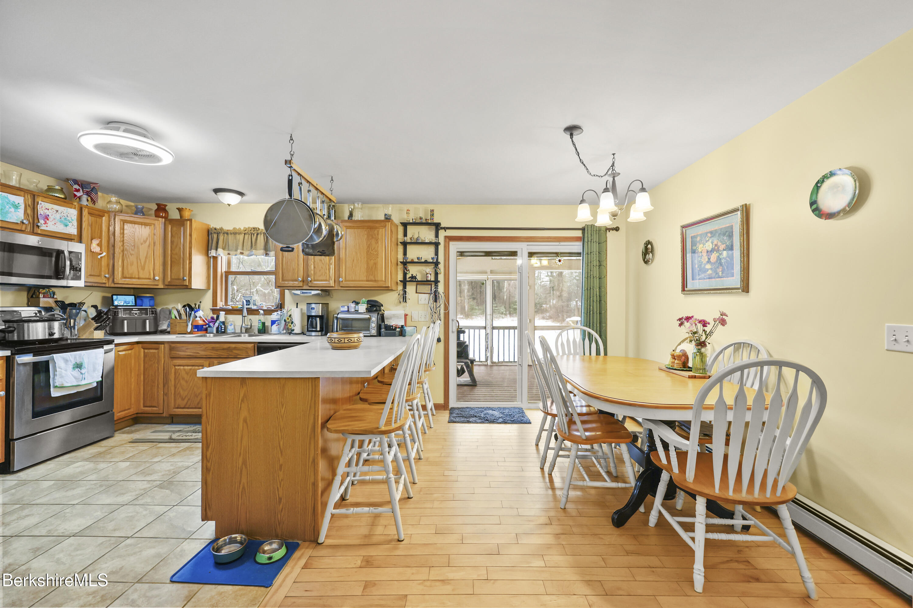 121 W Road Lee, MA 01238 - Photo 10 of 48 a dining room with stainless steel appliances a dining table and chairs