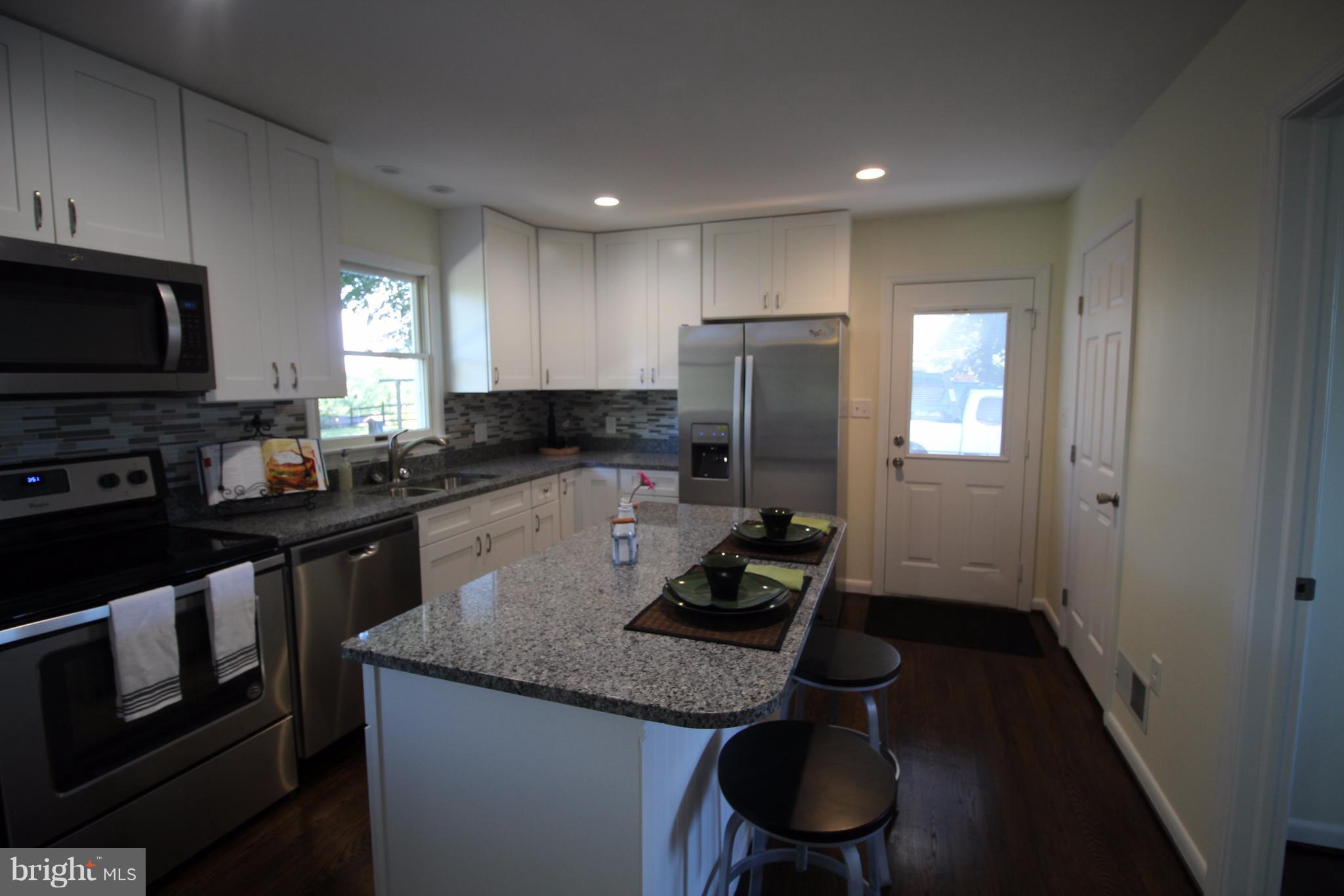 12805 Bunker Hill Road Union Bridge, MD 21791 - Photo 19 of 30 a kitchen with stainless steel appliances granite countertop a sink a stove a refrigerator cabinets and a window