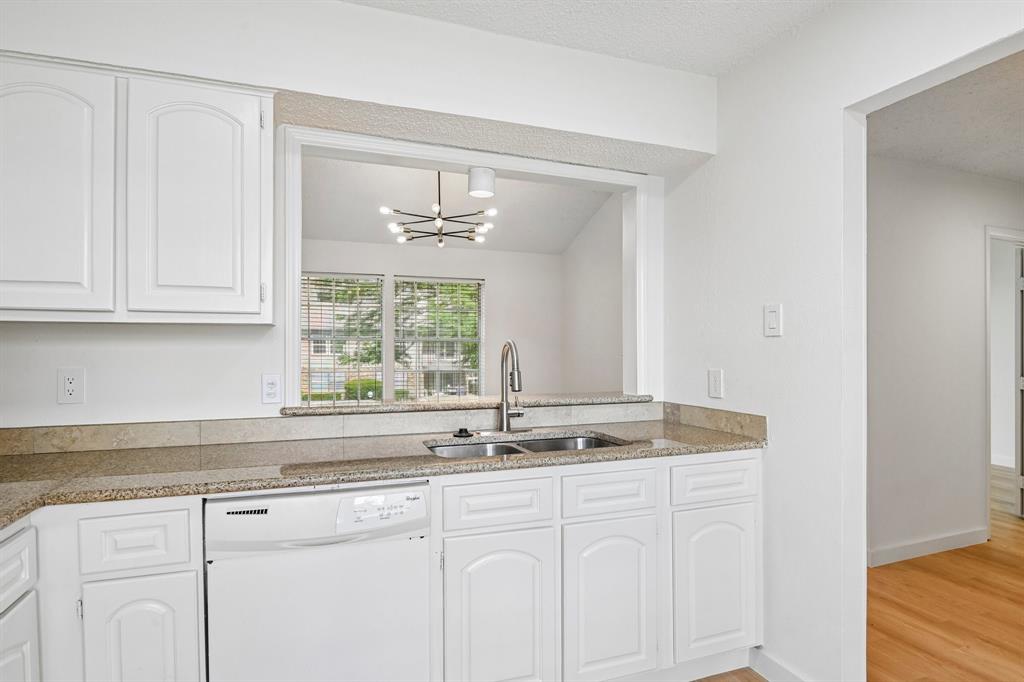 5300 Keller Springs Road, Unit 2055 Dallas, TX 75248 - Photo 5 of 24 Kitchen featuring white cabinetry, granite-finish countertops, and a double basin stainless steel sink with a high-arc faucet