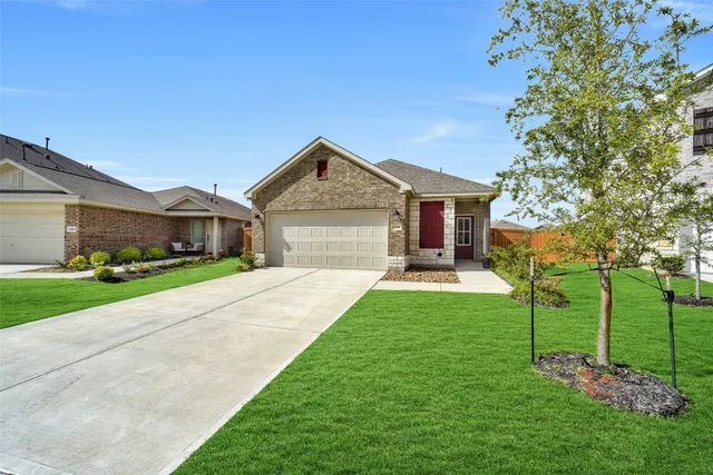 a front view of a house with a garden and trees