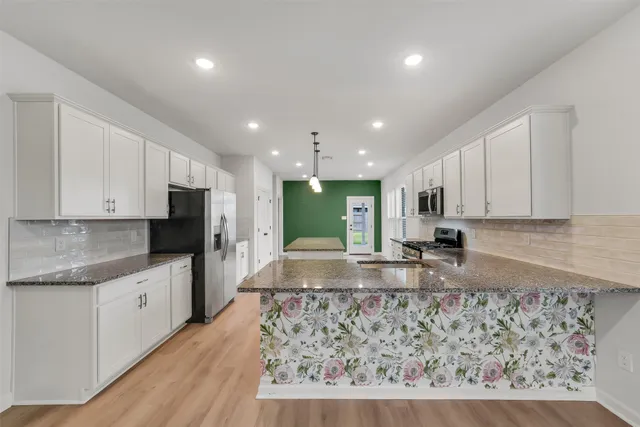 a large kitchen with kitchen island granite countertop a large counter top stainless steel appliances and cabinets