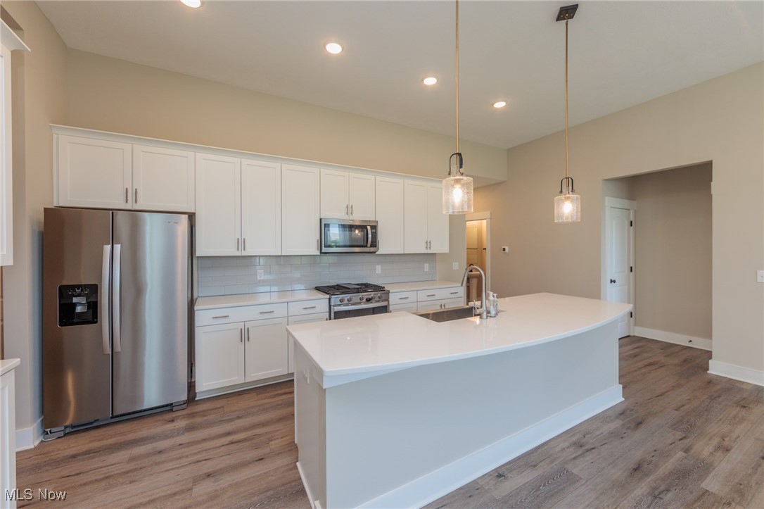 36458 Appian Way North Ridgeville, OH 44039 - Photo 5 of 37 Kitchen with sink, appliances with stainless steel finishes, white cabinetry, and a kitchen island with sink