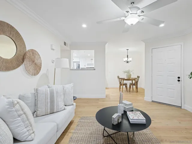 a living room with furniture a chandelier and a dining room
