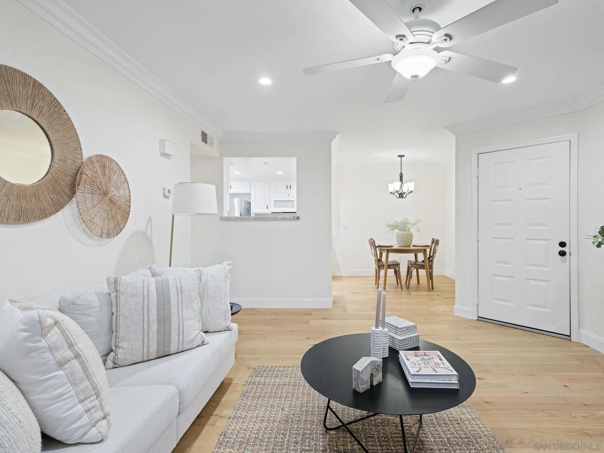 12023 Alta Carmel Court, Unit 244 San Diego, CA 92128 - Photo 5 of 16 a living room with furniture a chandelier and a dining room