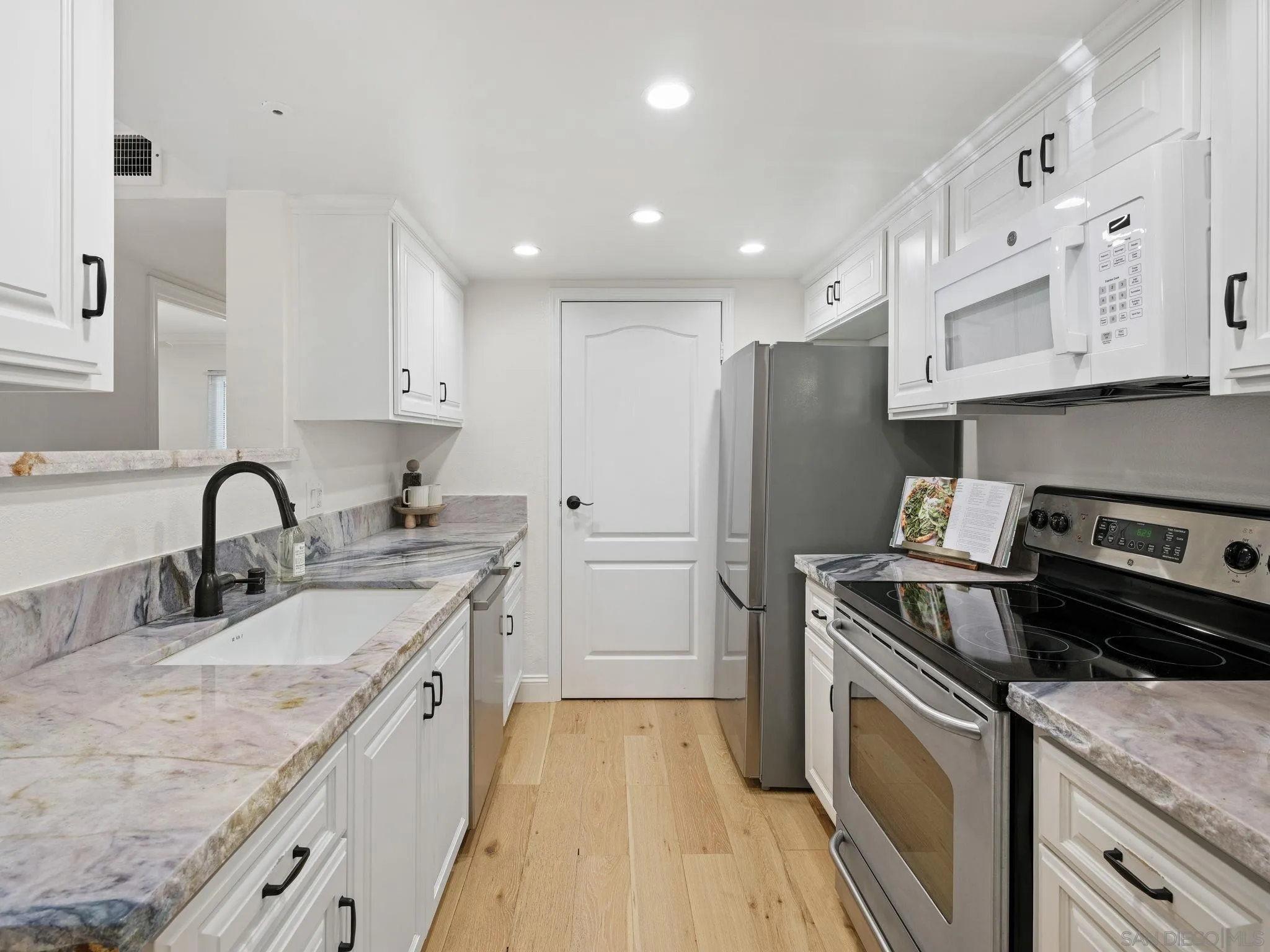 12023 Alta Carmel Court, Unit 244 San Diego, CA 92128 - Photo 7 of 16 a kitchen with stainless steel appliances granite countertop a sink stove and refrigerator