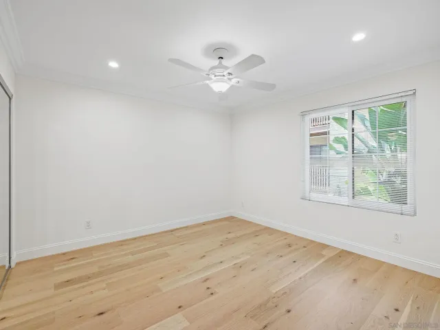 an empty room with a window and a fan