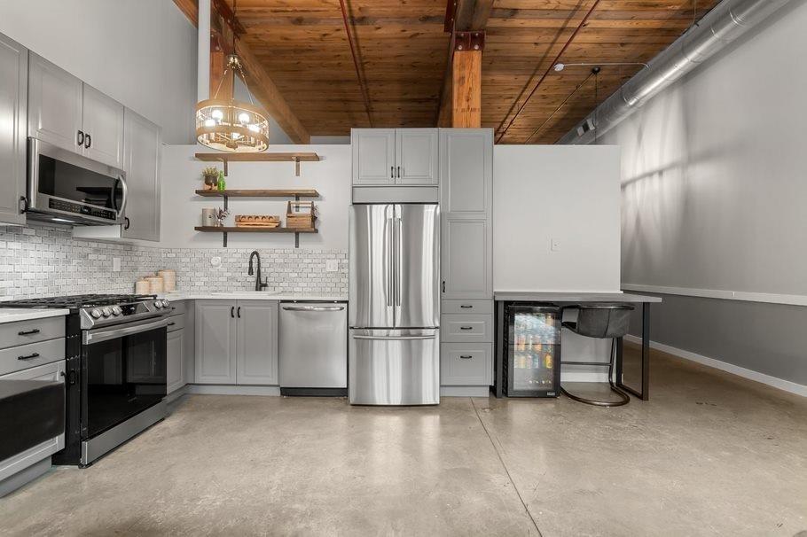 a kitchen with stainless steel appliances a refrigerator sink and microwave