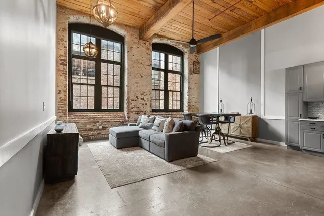 a living room with furniture and large windows