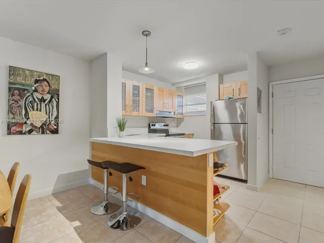 a kitchen with kitchen island a stove a refrigerator a sink and a refrigerator