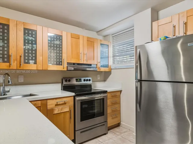 a kitchen with stainless steel appliances a refrigerator sink and cabinets