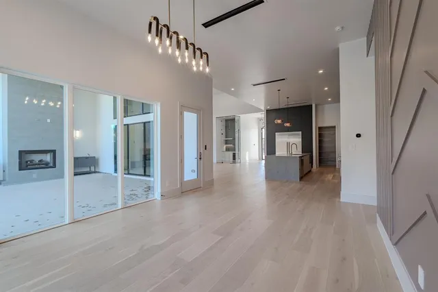 a view of a hallway with wooden floor and a glass door