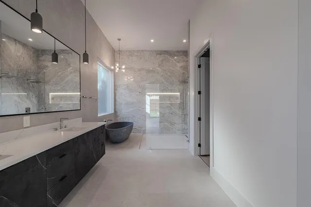 a bathroom with a double vanity sink toilet mirror and bathtub
