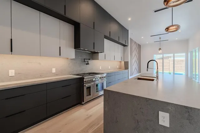 a kitchen with stainless steel appliances granite countertop a sink a stove and a refrigerator