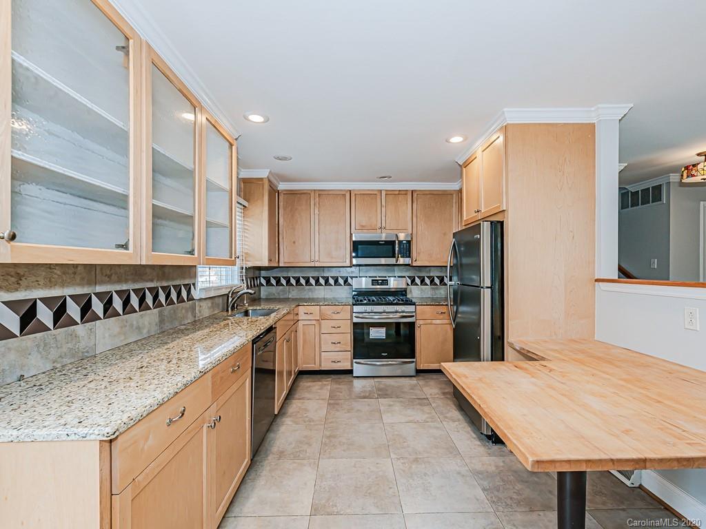 5706 Telfair Road Charlotte, NC 28210 - Photo 8 of 37 a kitchen with stainless steel appliances granite countertop a sink counter space cabinets and a large window