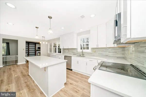 a kitchen with stainless steel appliances granite countertop a sink stove and microwave