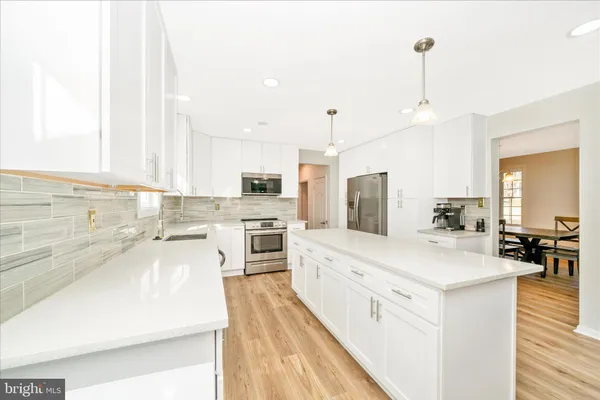 a large kitchen with a lot of counter space and stainless steel appliances