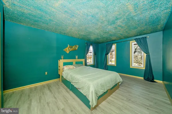 a bedroom with a bed and a flat tv screen on dresser