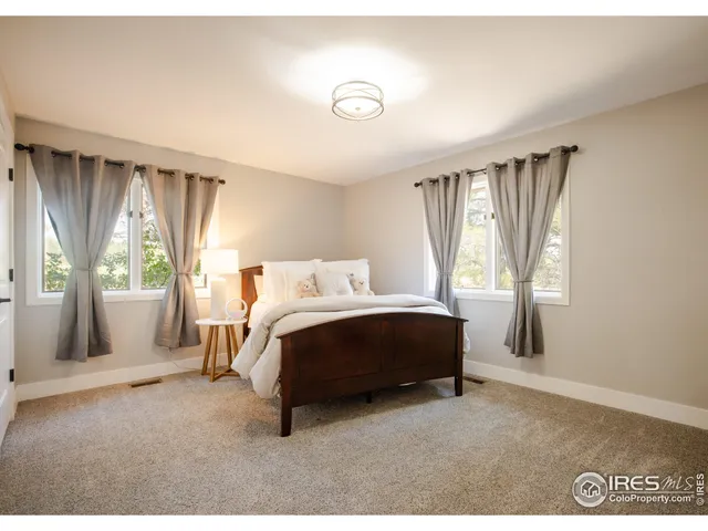 a bedroom with a bed and a large window