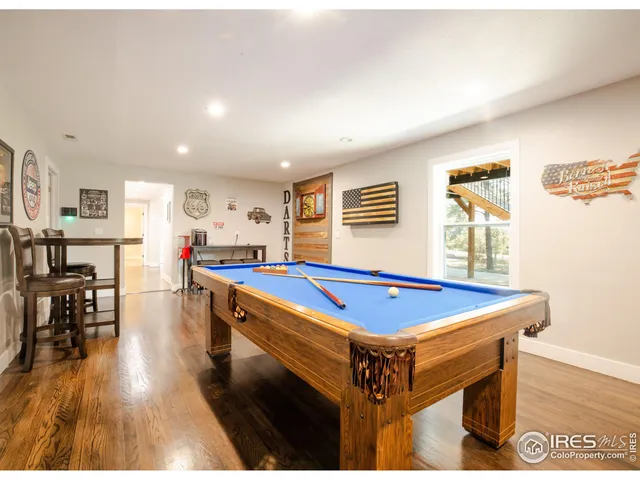 a room with pool table and windows