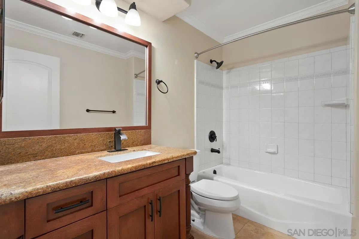 4103 Fallsbrae Road Fallbrook, CA 92028 - Photo 20 of 48 a bathroom with a granite countertop sink a toilet a mirror and shower