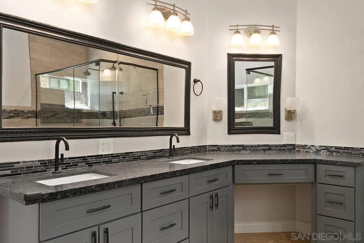 4103 Fallsbrae Road Fallbrook, CA 92028 - Photo 28 of 48 a bathroom with a granite countertop sink a large mirror and a window