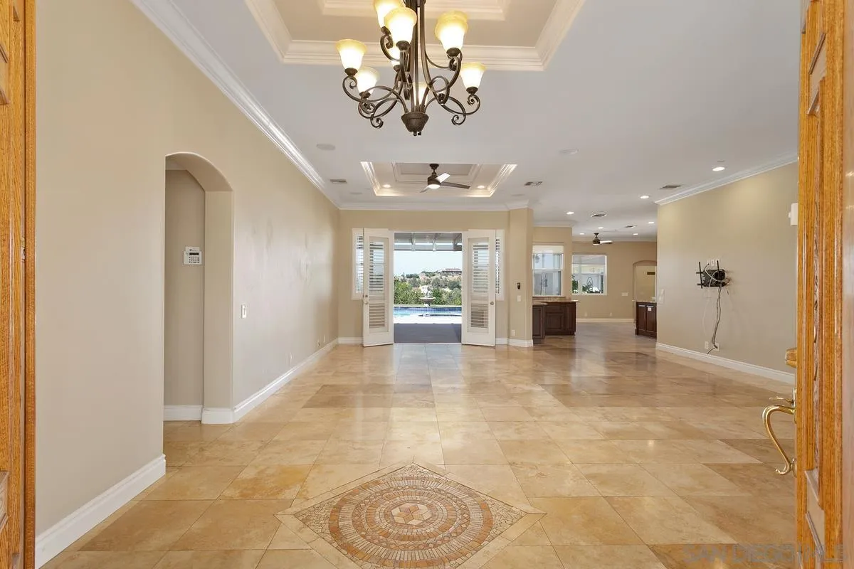 4103 Fallsbrae Road Fallbrook, CA 92028 - Photo 8 of 48 a view of a hallway with a chandelier and dining table