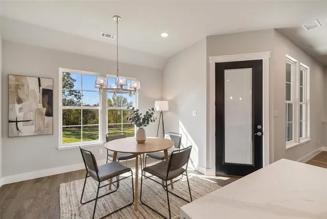 a dining room with furniture a chandelier and wooden floor