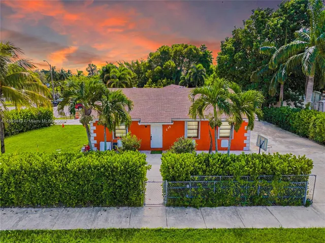 a front view of a house with a yard and potted plants