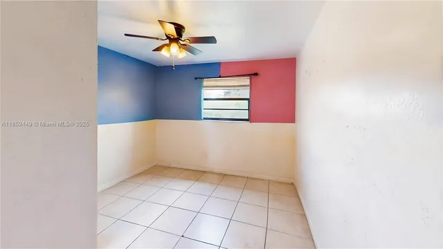 an empty room with closet and a ceiling fan