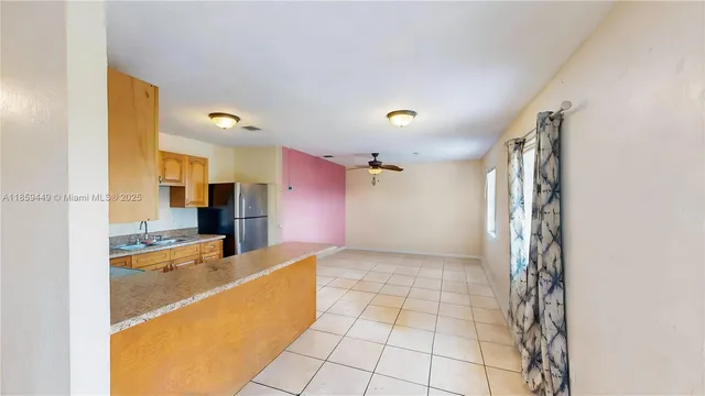 a view of a kitchen with kitchen island granite countertop a refrigerator and a sink