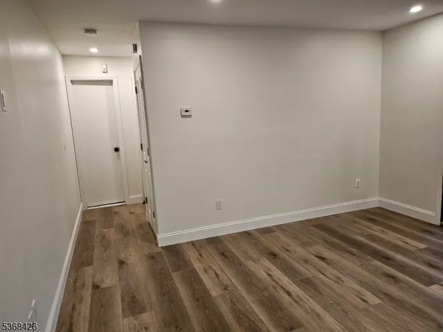 a view of a room with wooden floor and white walls