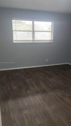a view of a small space with wooden floor and a window