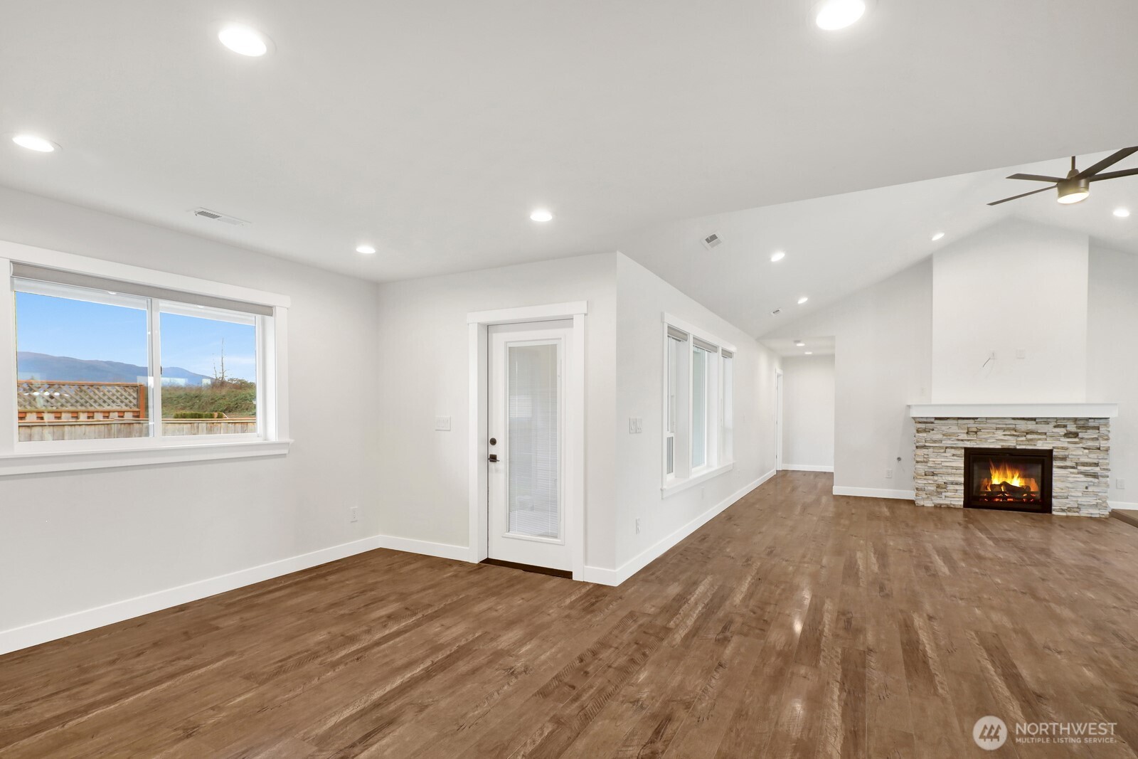 1302 Night Hawk Way Everson, WA 98247 - Photo 14 of 35 an empty room with windows a fireplace and wooden floor
