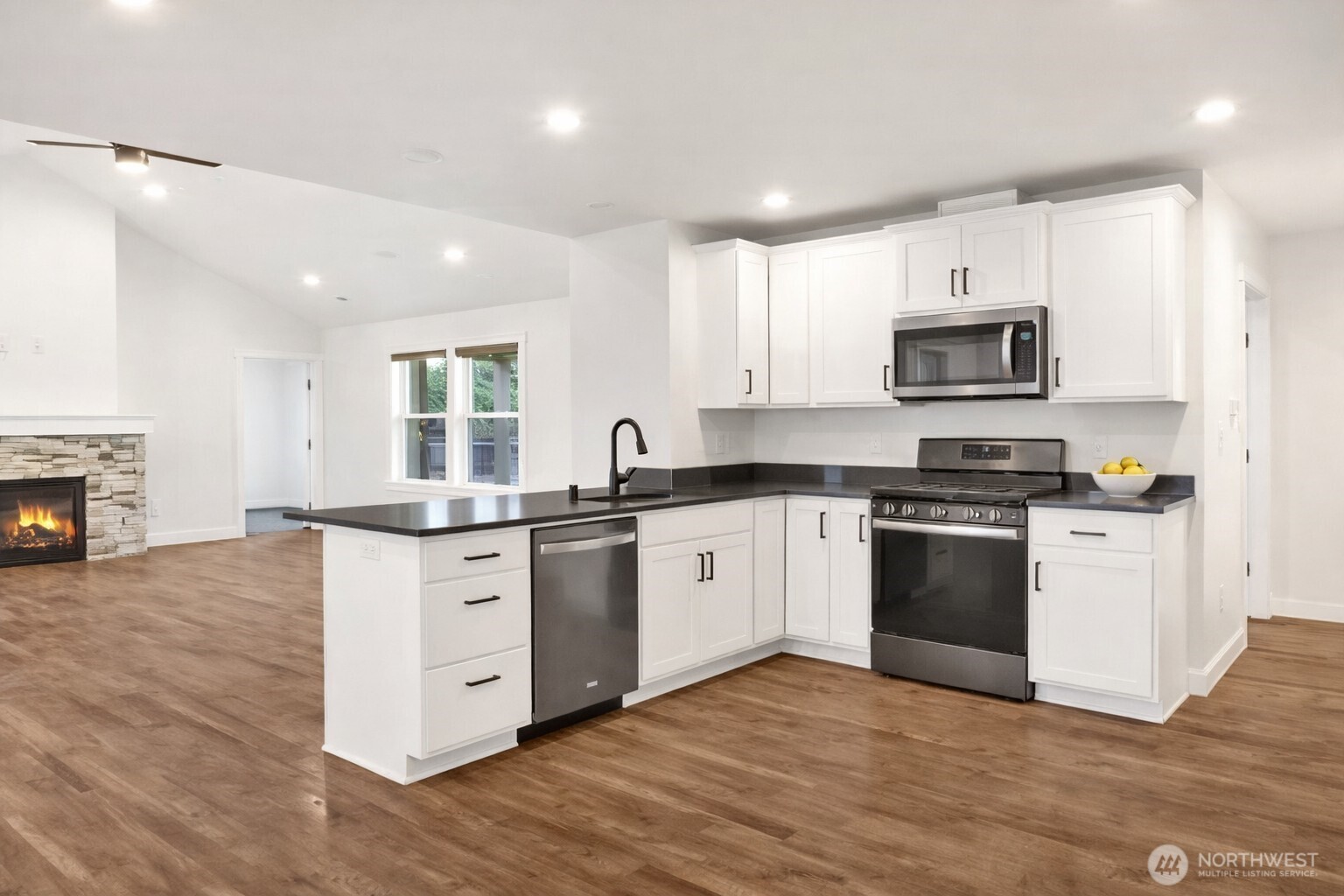 1302 Night Hawk Way Everson, WA 98247 - Photo 17 of 35 a kitchen with stainless steel appliances granite countertop a stove top oven a sink and a granite counter tops with wooden floors