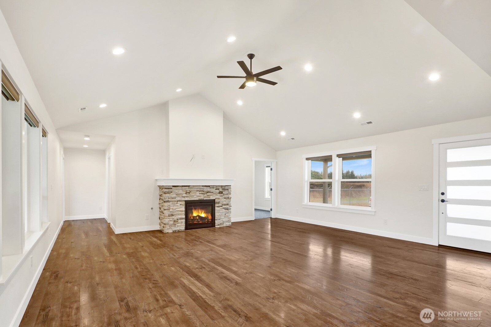 1302 Night Hawk Way Everson, WA 98247 - Photo 7 of 35 an empty room with windows fireplace and wooden floor