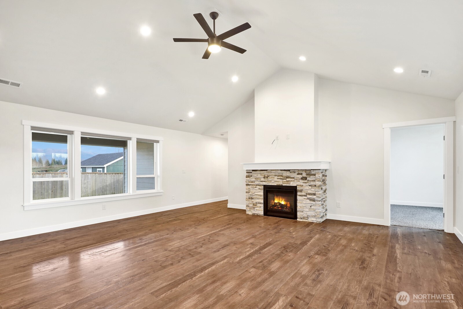 1302 Night Hawk Way Everson, WA 98247 - Photo 8 of 35 an empty room with fireplace wooden floor and windows