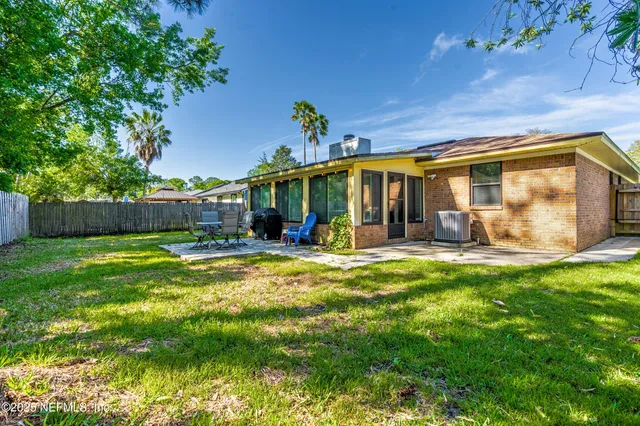 a view of a house with backyard and sitting area