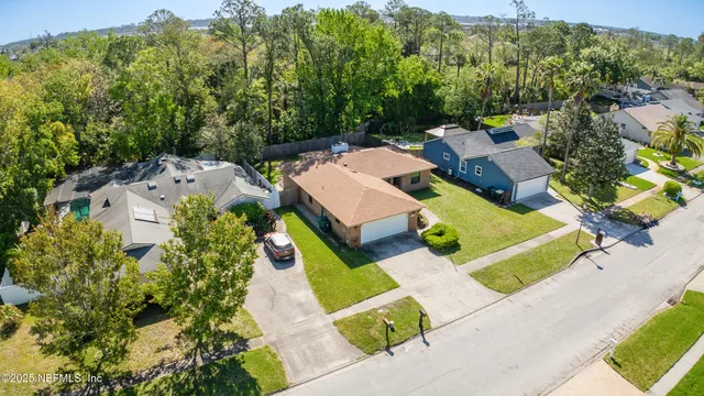 an aerial view of a house with a garden and lake view