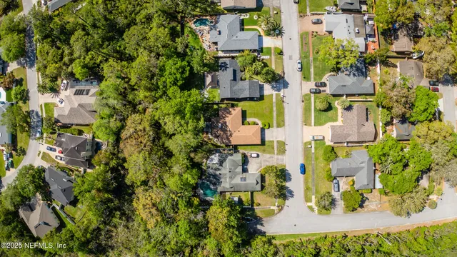 an aerial view of residential houses with outdoor space and parking