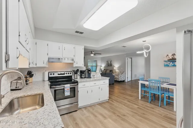 a kitchen with stainless steel appliances a sink stove refrigerator and cabinets