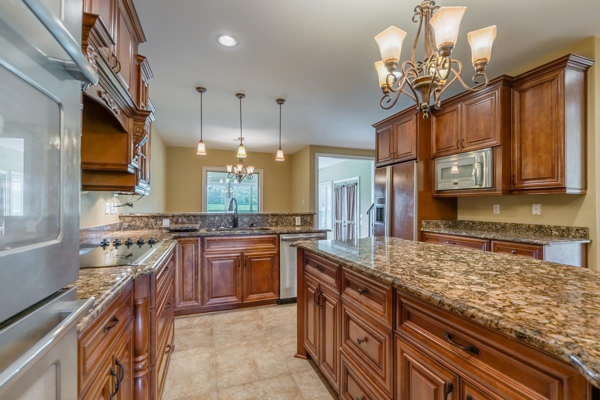 8250 Deadfall Road Millington, TN 38053 - Photo 12 of 26 a kitchen with stainless steel appliances granite countertop a sink a stove top oven a counter space and cabinets