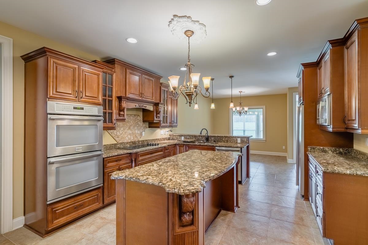 8250 Deadfall Road Millington, TN 38053 - Photo 14 of 26 a kitchen with kitchen island granite countertop a sink stove and refrigerator