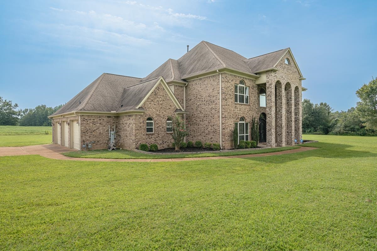8250 Deadfall Road Millington, TN 38053 - Photo 2 of 26 a view of a big house with a big yard and large trees