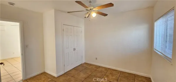 an empty room with a window and a ceiling fan