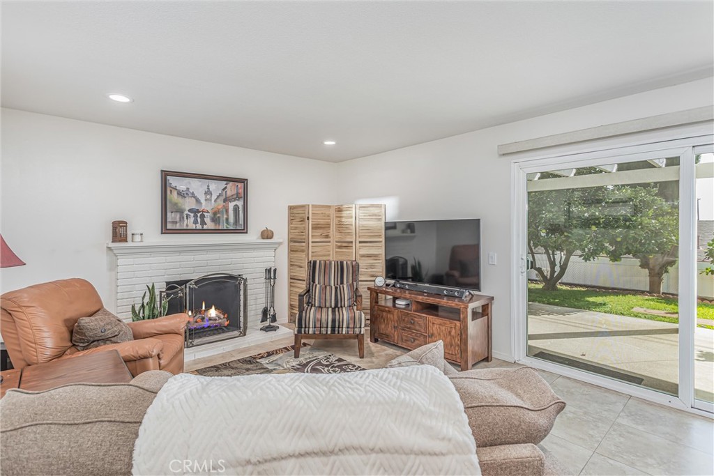 8651 Holly Street Rancho Cucamonga, CA 91701 - Photo 2 of 29 a living room with furniture a flat screen tv and a fireplace